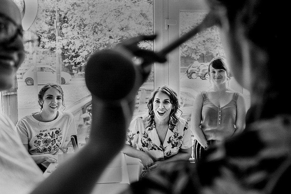 Bridesmaid watch bride have make-up applied before St Luke's Bombed Out Church wedding