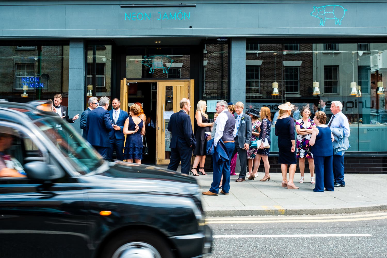 Guests socialising before St Luke's Bombed Out Church wedding