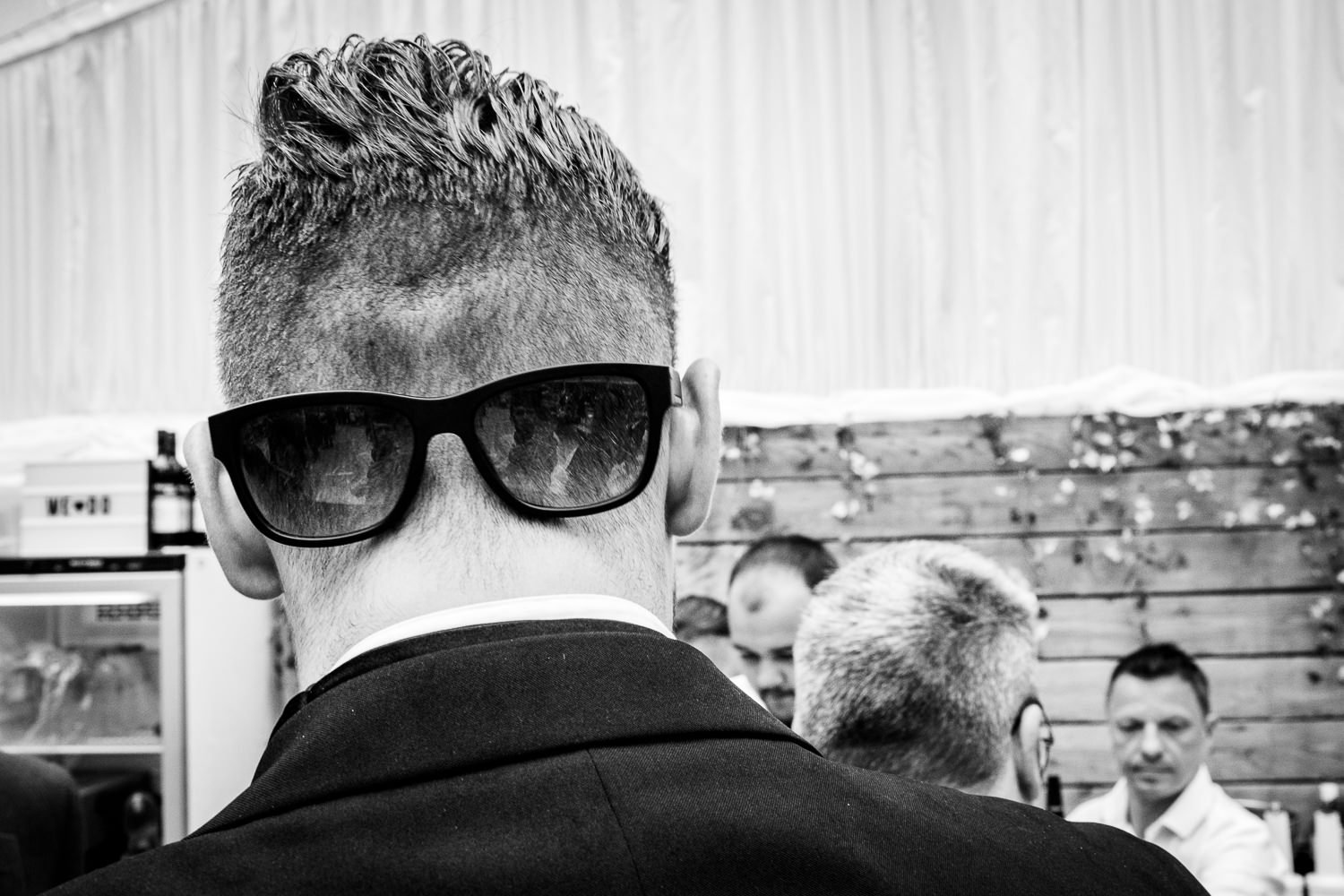 Guest wearing sunglasses on the back of his head at St Luke's Bombed Out Church wedding