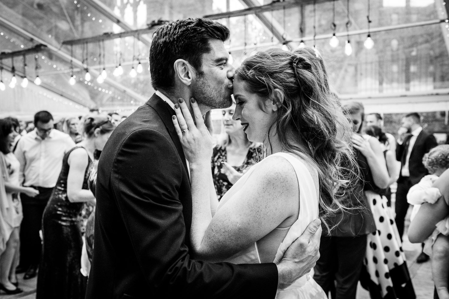 Groom kisses the bride at St Luke's Bombed Out Church wedding