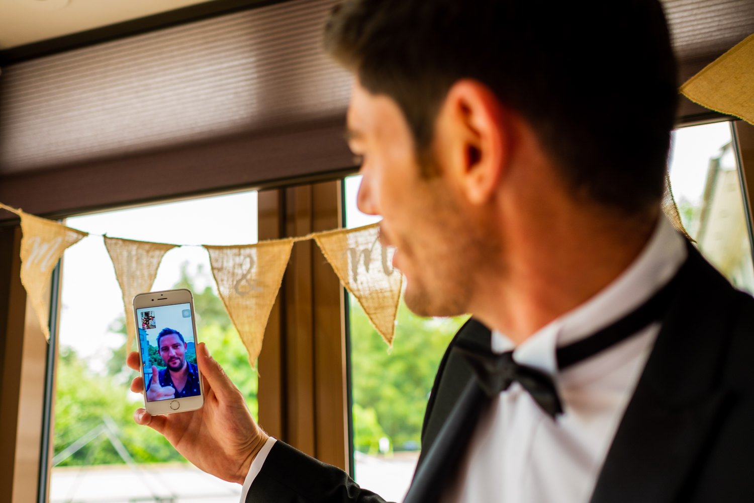 Groom talks on the phone before St Luke's Bombed Out Church wedding