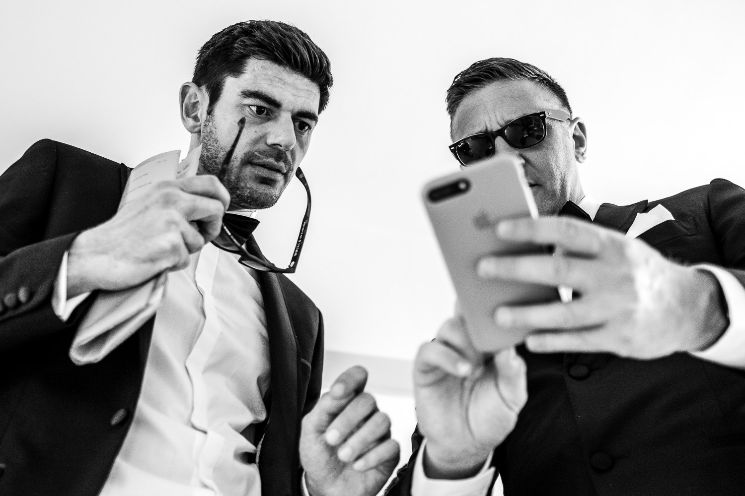 Groom and best man check phone before St Luke's Bombed Out Church wedding