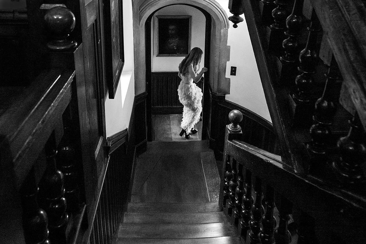 A bride walks down the stairs after a London wedding ceremony at Bride and bridesmaids walk to the wedding ceremony at the Church of St John in Clerkenwell