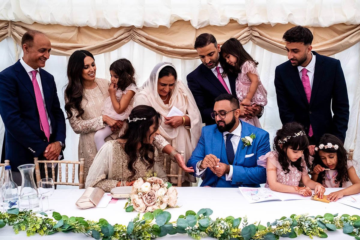 Bride and groom and family at the top table during an Asisn nikah and garden wedding in Hale