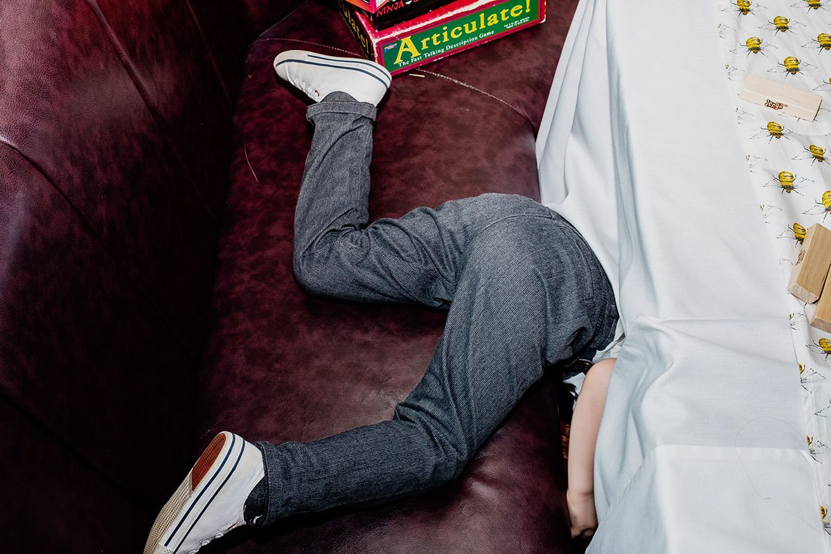 Boy's legs as he climbs under a table at a wedding breakfast