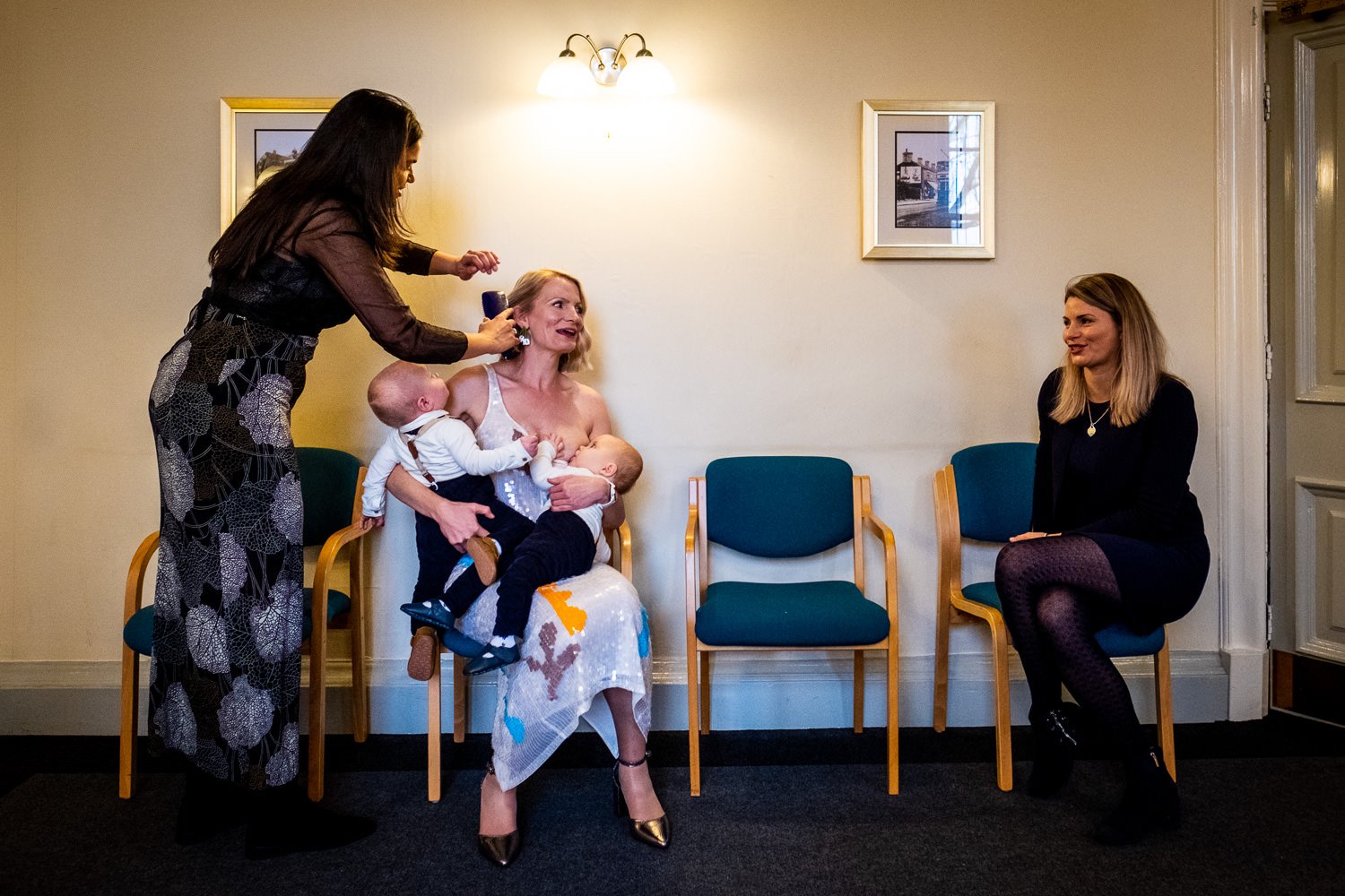 Bride has her hair styled as she holds her twins