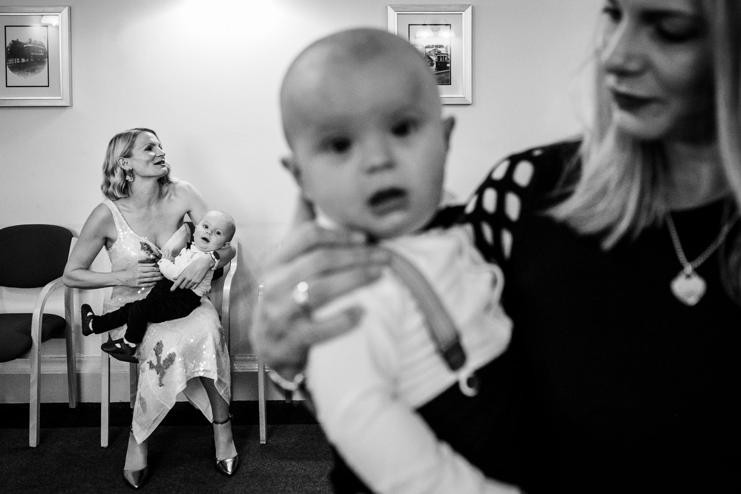 Bride and sister hold a twin apiece as they wait for the wedding ceremony