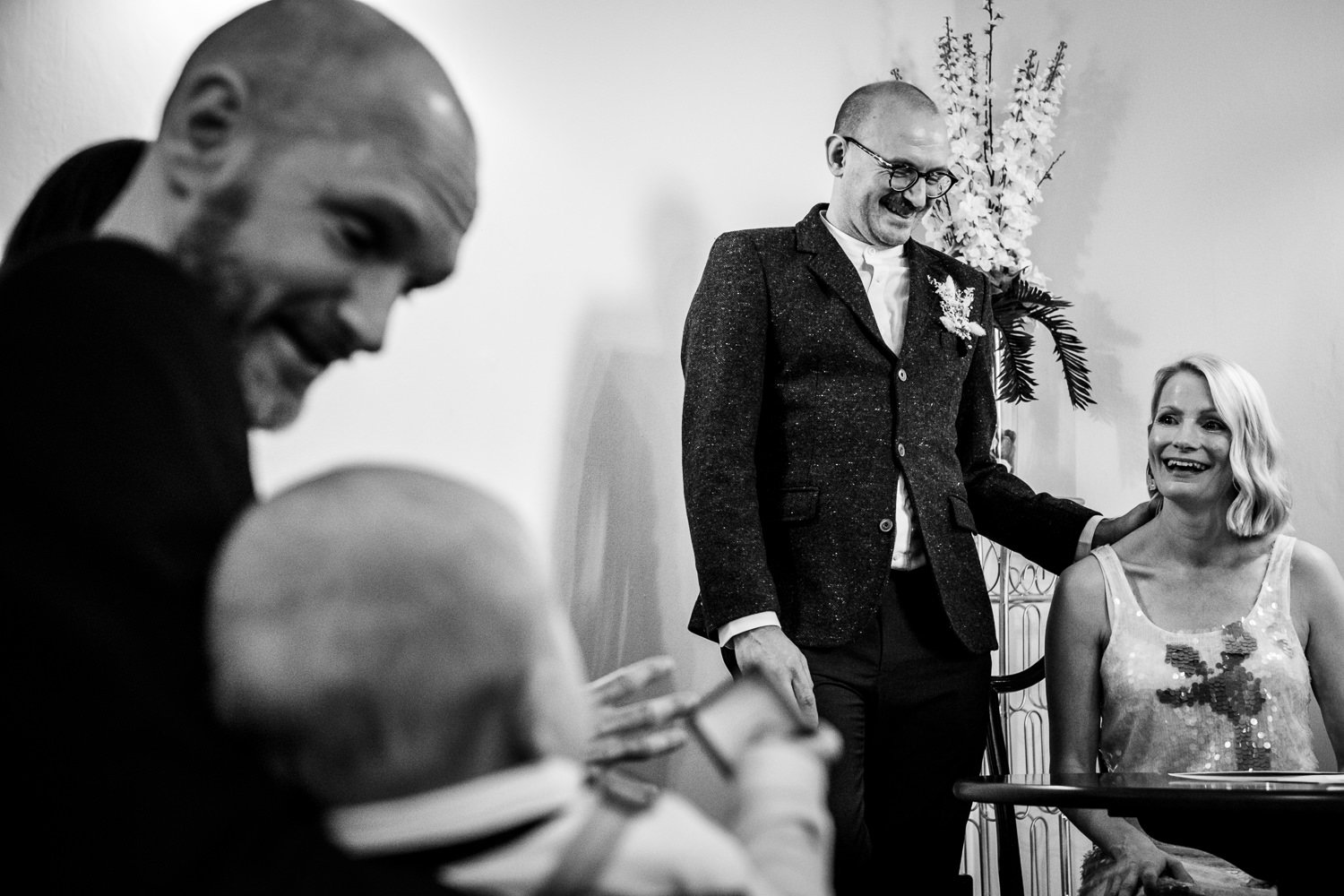 Bride and groom laugh as one of their sons watches