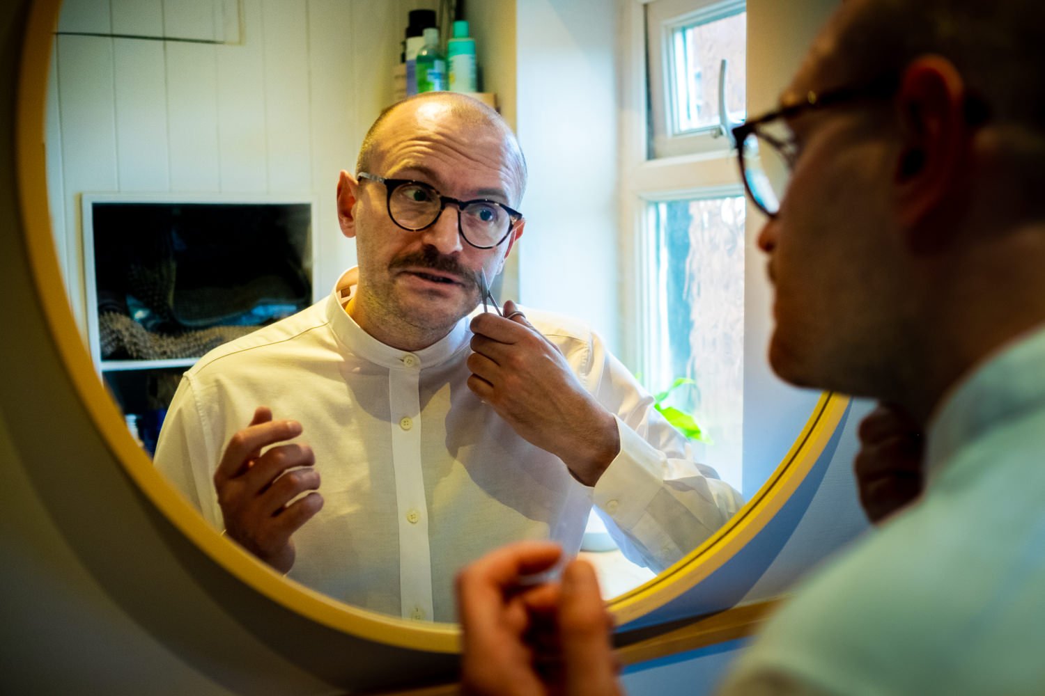 Groom trims his moustache before leaving for his wedding