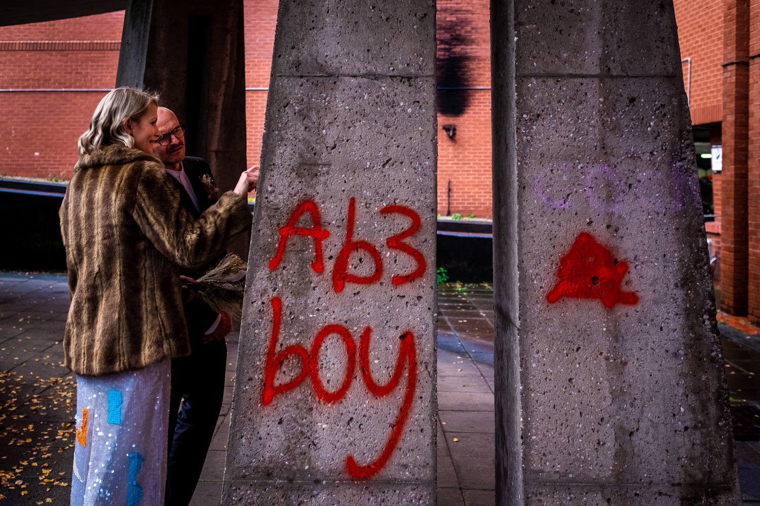 Bride and groom inspect graffiti after getting married at Stockport Town Hall