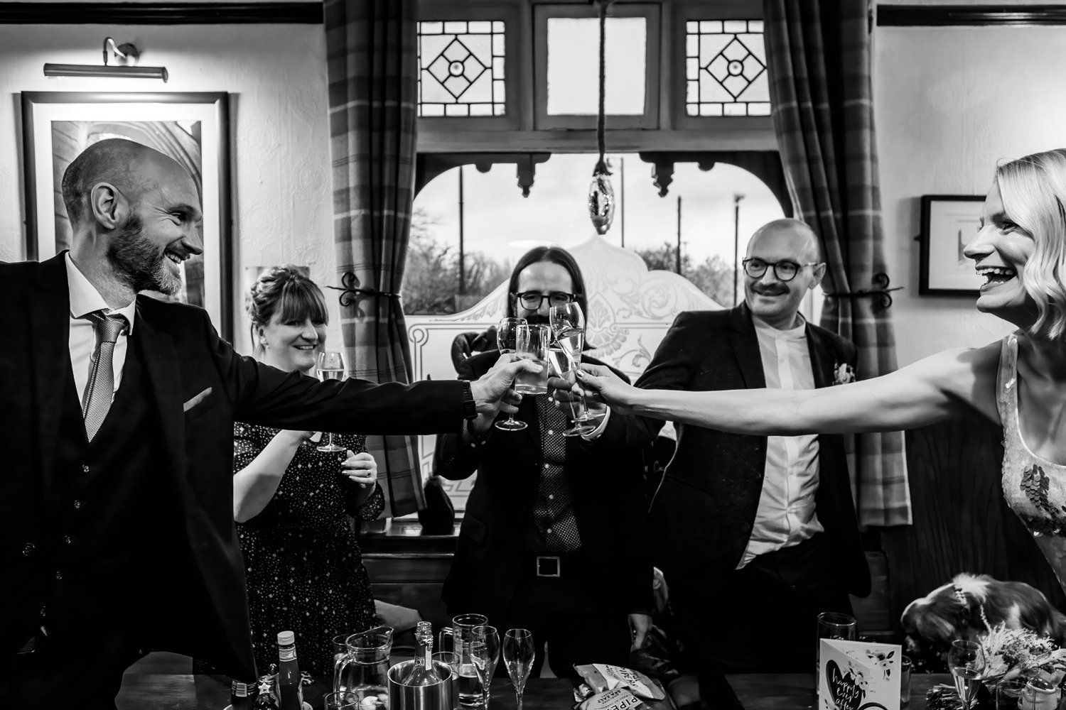 Bride and groom and guests raise a glass at the Arden Arms