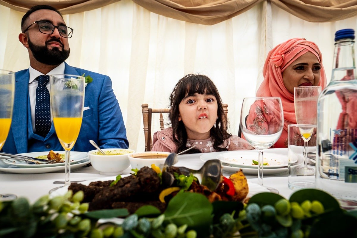 A child pulls a funny face during a Cheshire garden wedding