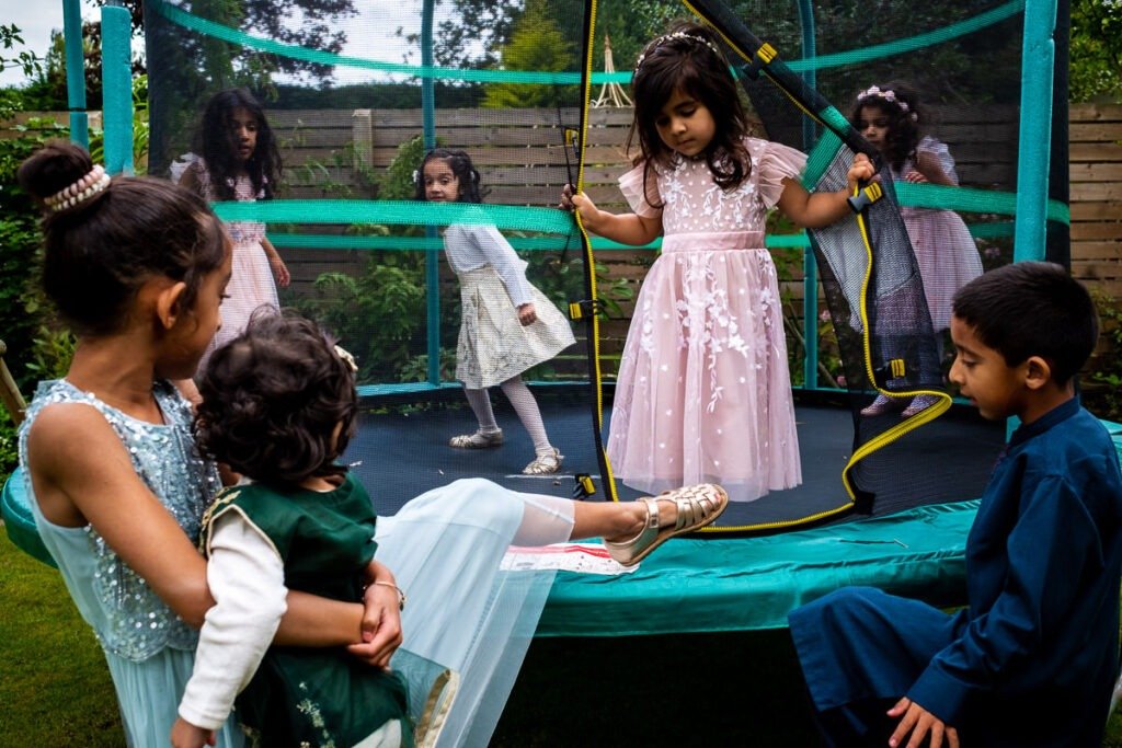 Children play on a trampoline at a Cheshire garden wedding