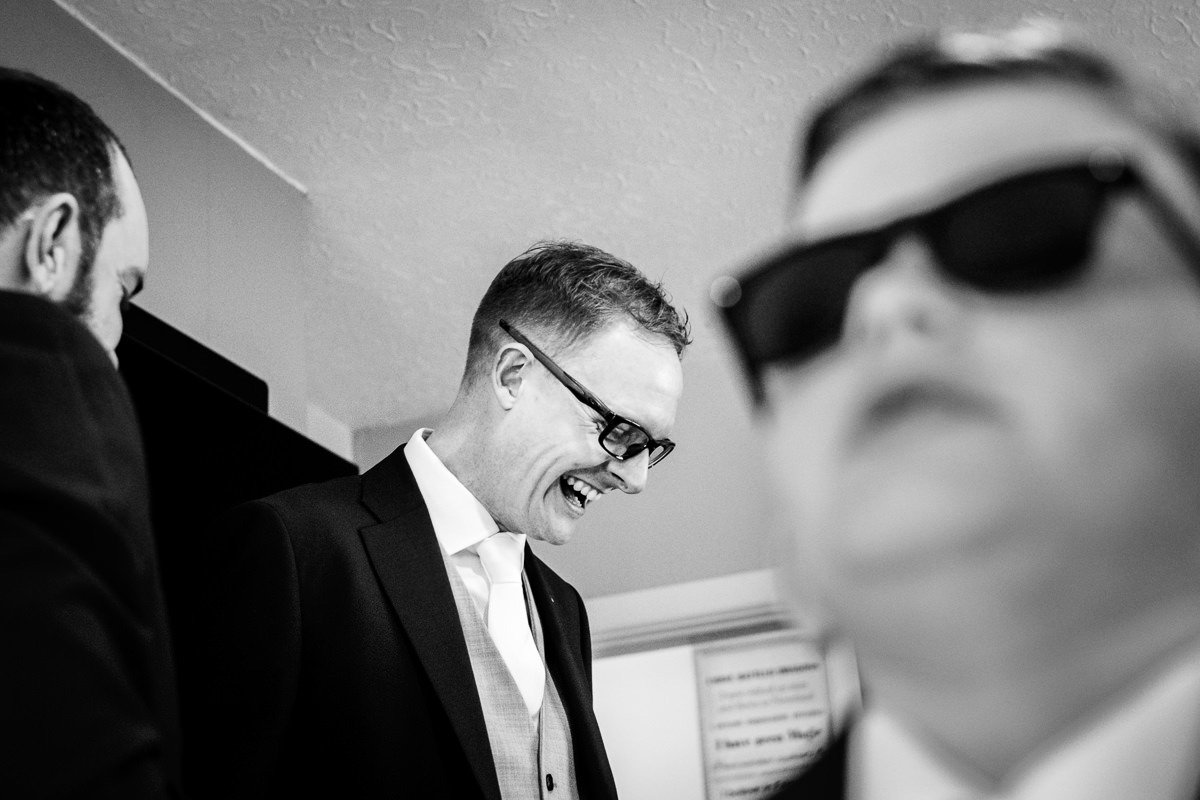 The groom laughs while getting ready for a Singleton Lodge wedding