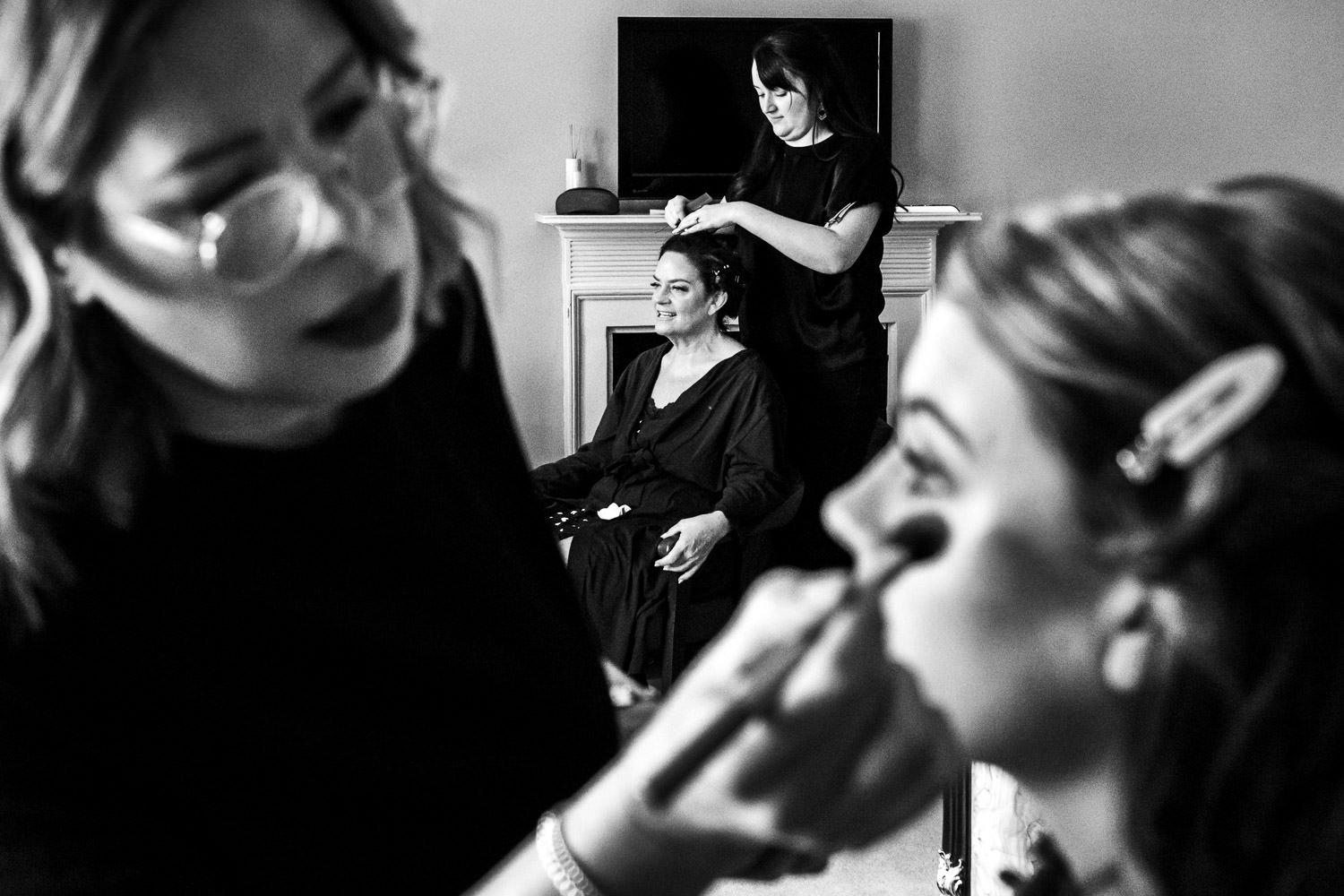 Bridesmaid has make-up applied as bride has hair styled before Grays Court wedding