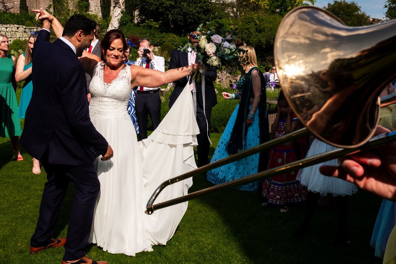 Bride and groom dancing to brass band in Grays Court garden