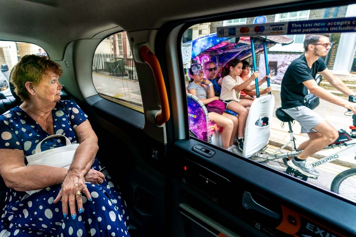 Mother of groom looks out of taxi window on way to wedding ceremony at One Great George Street