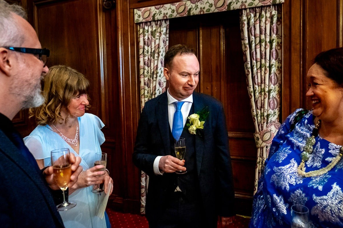 Groom pulls a funny face while talking to guests after ceremony