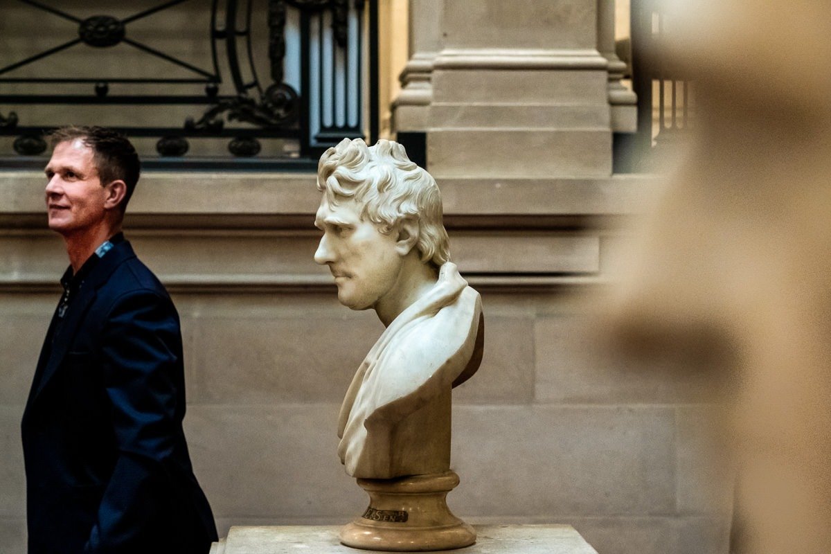 Guest walks past statues during One Great George Street wedding