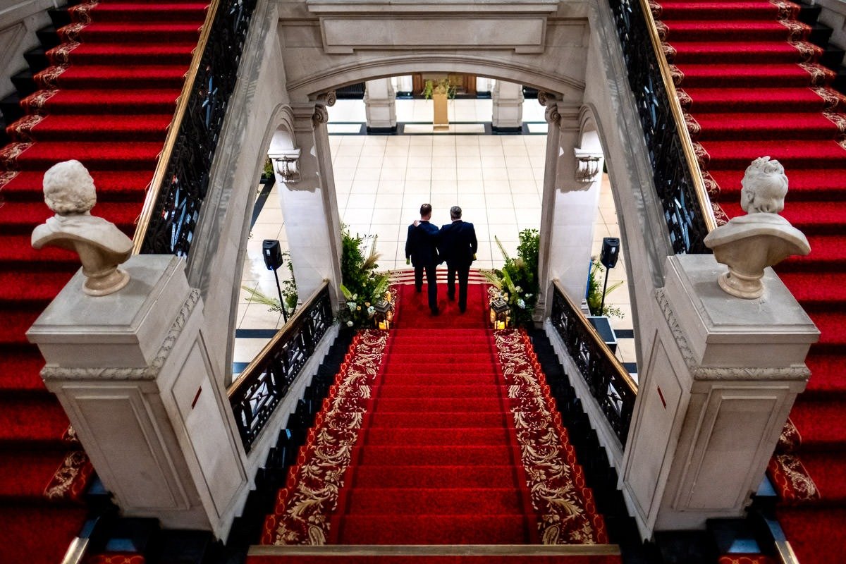 Grooms walk down stairs at One Great George Street