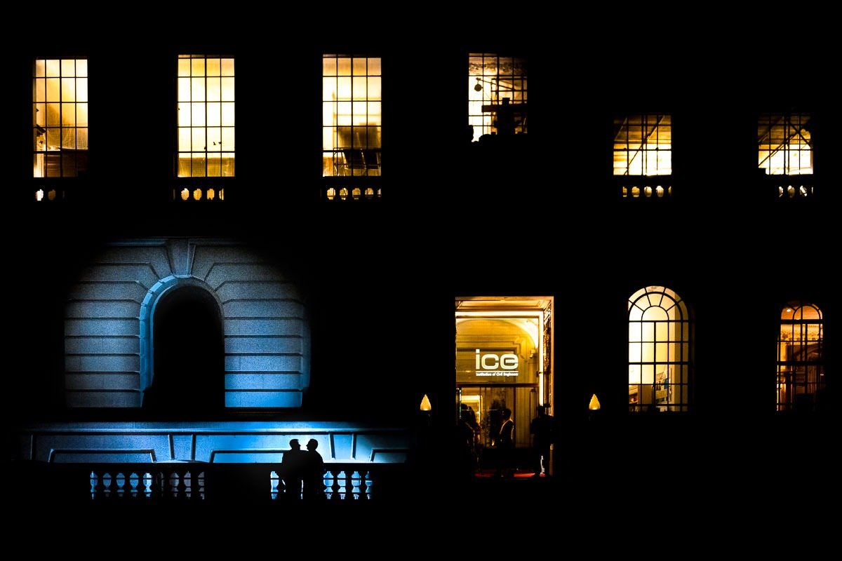 Groom stand outside One Great George Street at night