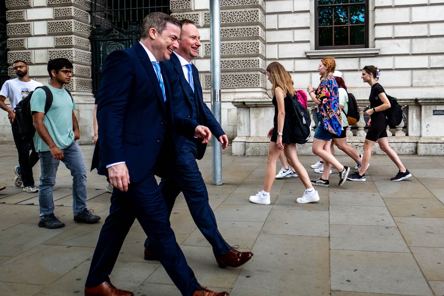 Grooms walk down One Great George Street after wedding ceremony