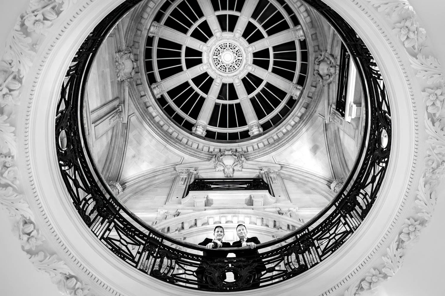 Grooms look down from rotunda at One Great Goerge Street wedding