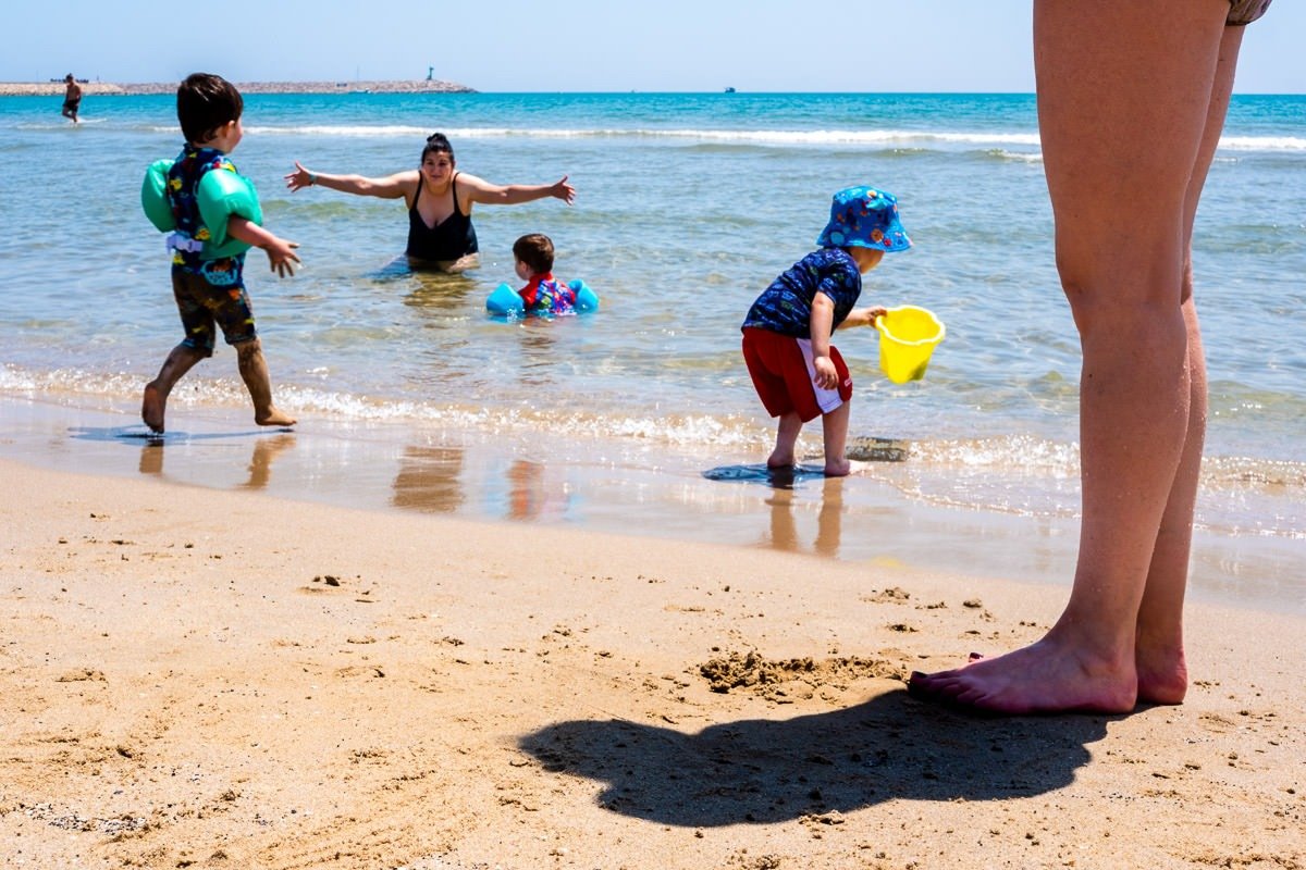 Family plays on beach in Vilanova i la Geltrú, Spain