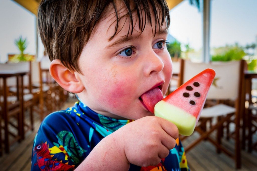 Child eats ice lolly on beach in Vilanova i la Geltrú, near Barcelona