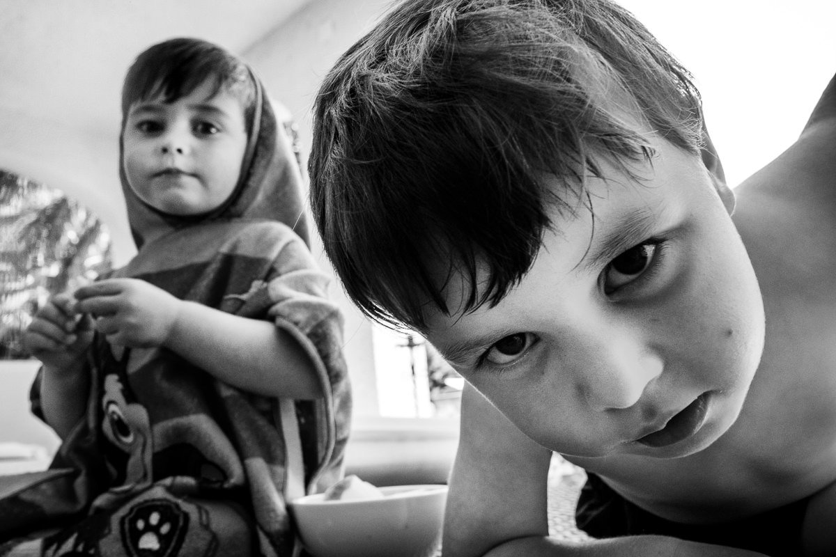 Close-up of child looking at camera as another child looks on