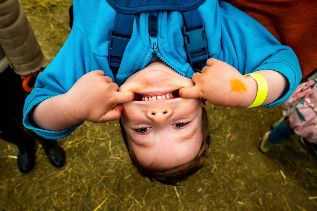 Child smiles while hanging upside down