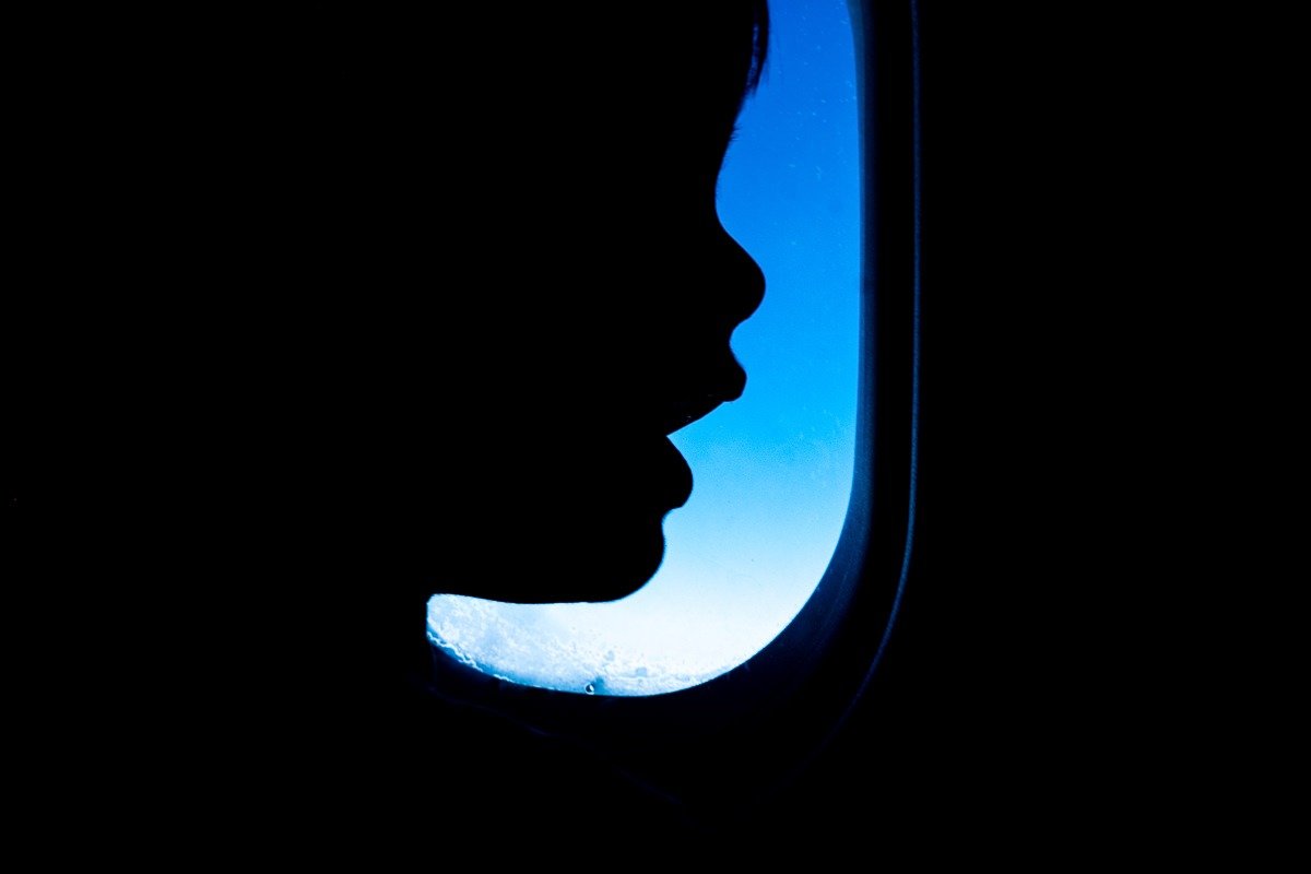 Child in front of plane window during flight