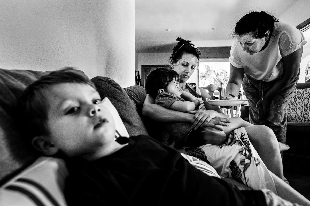 Child watches TV as another child is offered food