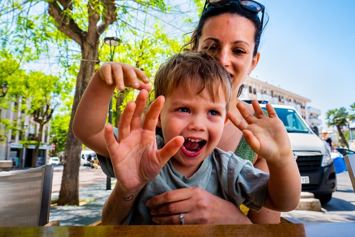 Mother and soon laughing at restaurant in Spain