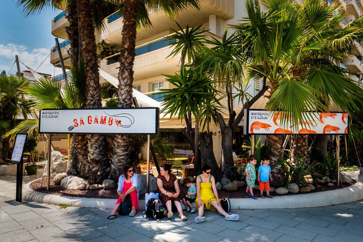 Families sit outside restaurant in Sitges, Spain