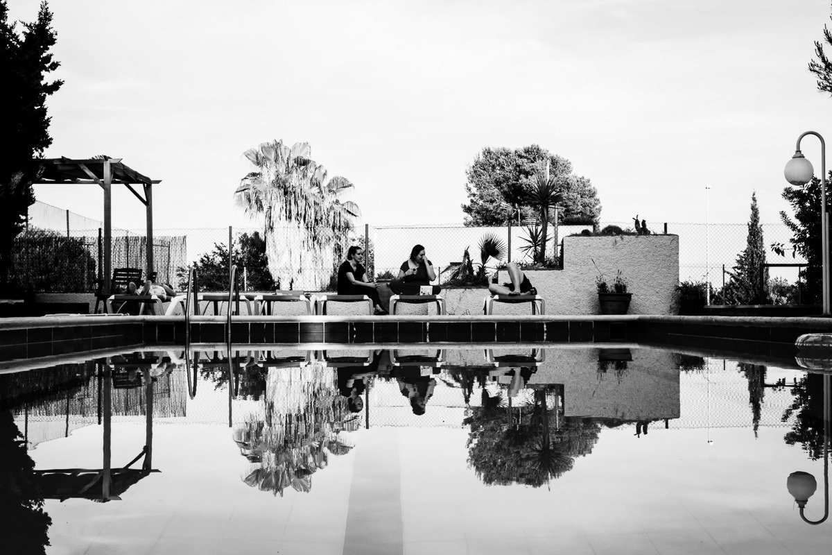 People lie on sunbed at end of swimming pool at villa in Vilanova i la Geltrú near Barcelona