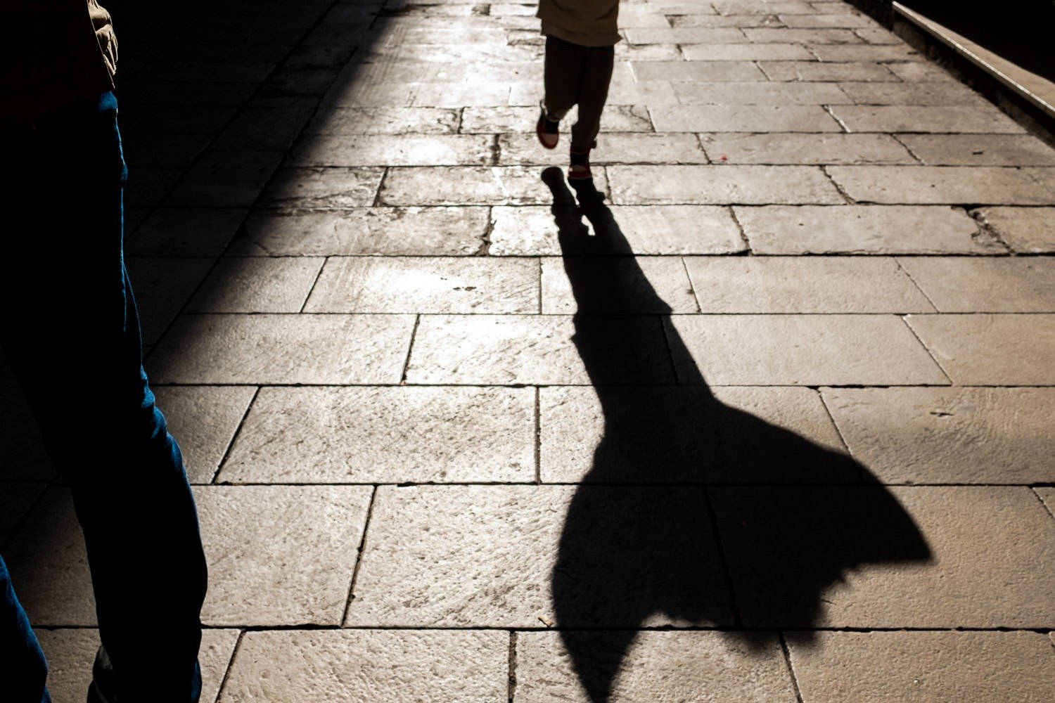 Silhouette of child running down Barcelona street