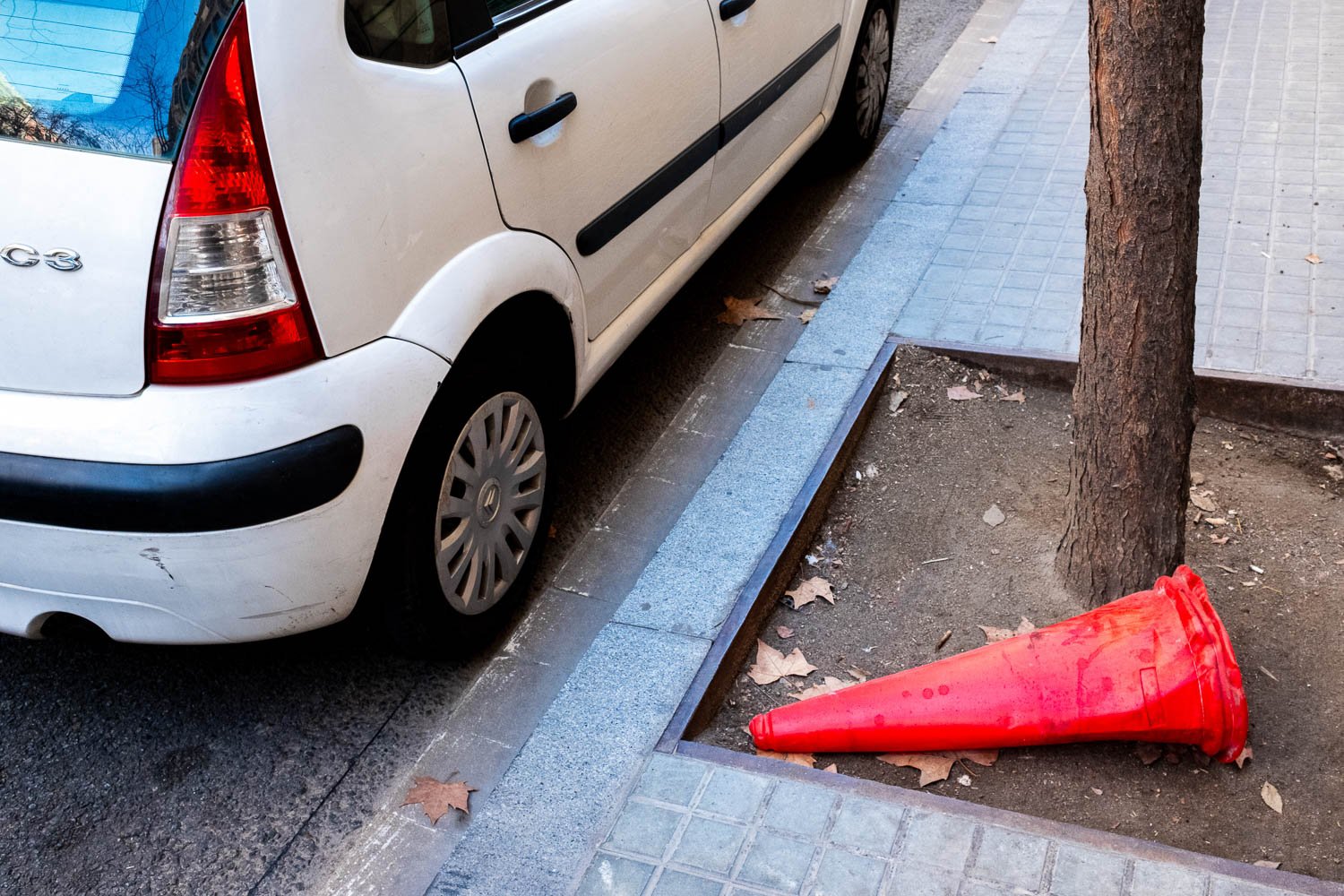 Red street cone next to car and red light