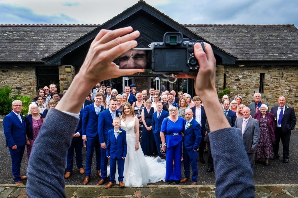 Photographer takes group photo at a Mytton Fold wedding in the Ribble Valley, Lancashire