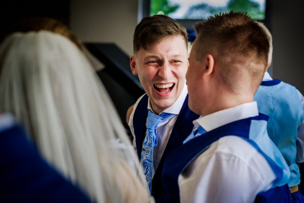 Best man laughs with the groom during the wedding breakfast at a Mytton Fold wedding