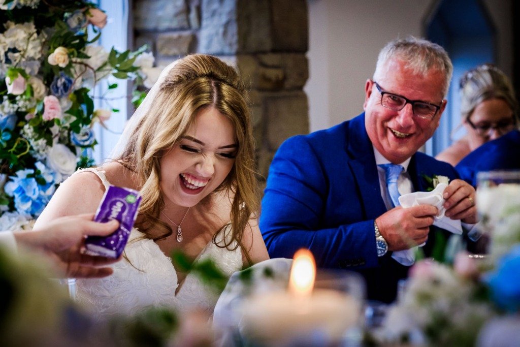 Bride and father laugh during the groom's speech at a Mytton Fold wedding in Lancashire