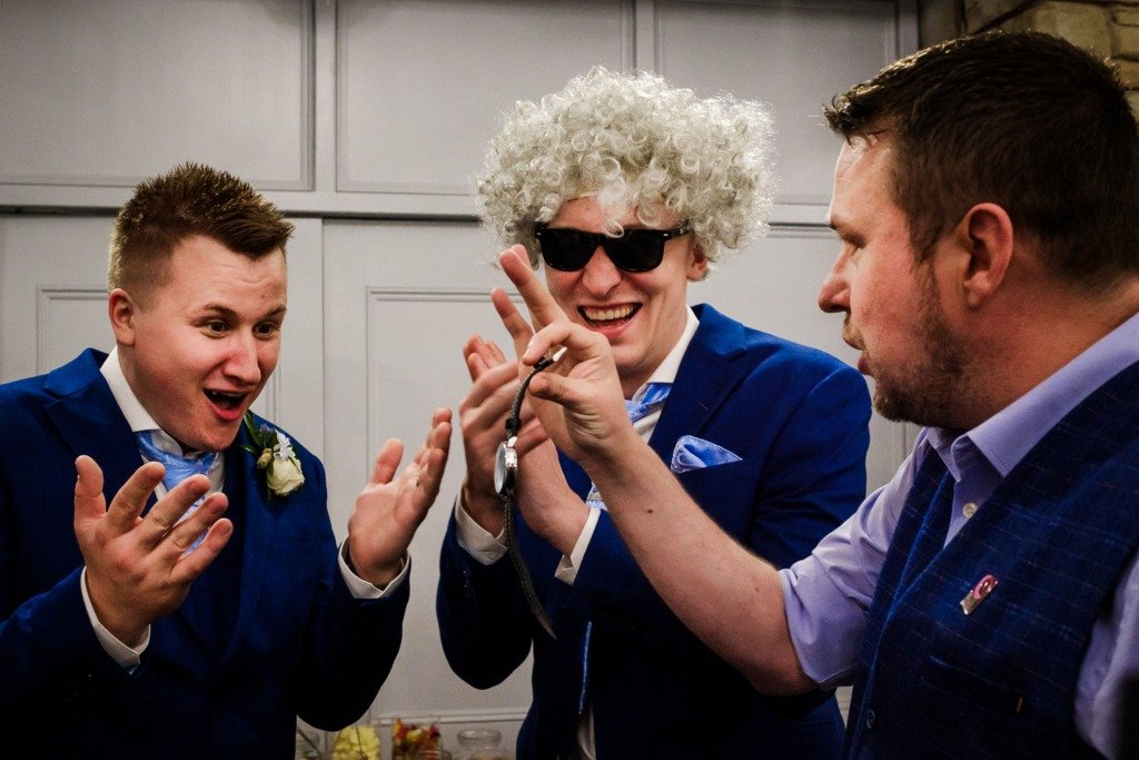 A groom and his best man show shock after a magician revels a watch as part of a trick at a Mytton Fold Hotel wedding