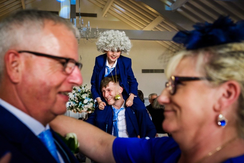 A child on the best man's shoulders as a couple dance at a Mytton Fold wedding