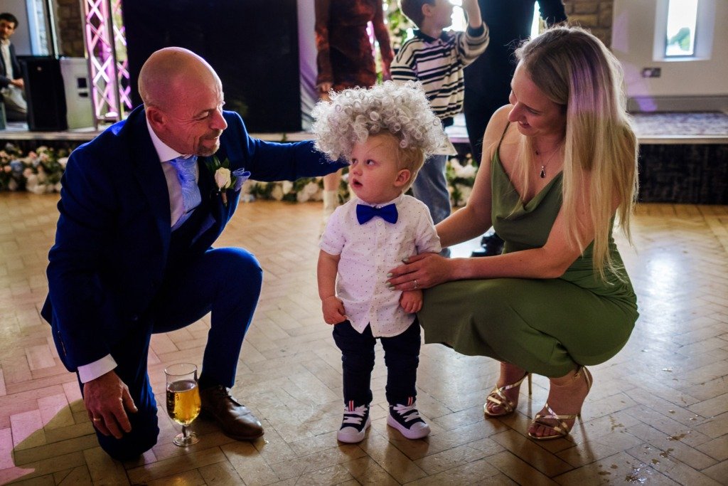 A child wears a wig during a Mytton Fold wedding celebration