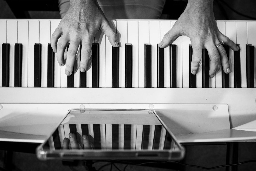 Reflection of a keyboard and keyboard player's fingers on the day of a Mytton Fold wedding