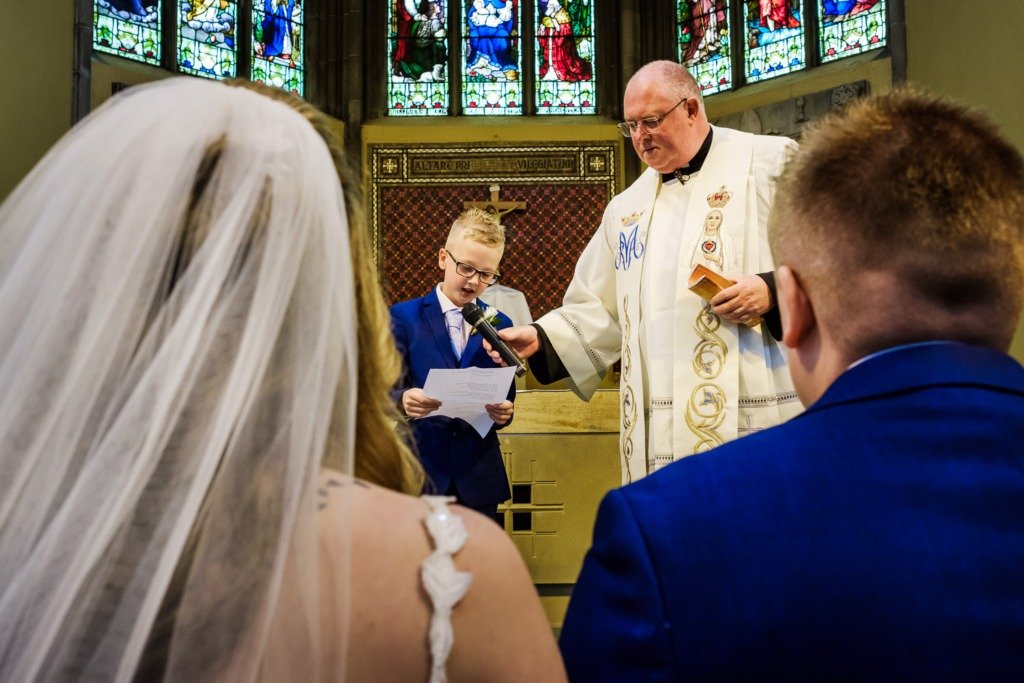 The bride and groom's son performs a reading at a Pleasington Priory wedding service in Blackburn